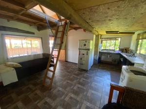 a room with a bunk bed and a kitchen with a ladder at Hare Sunset Rapa Nui in Hanga Roa