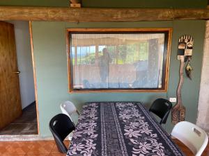 a table and chairs in a room with a window at Hare Sunset Rapa Nui in Hanga Roa