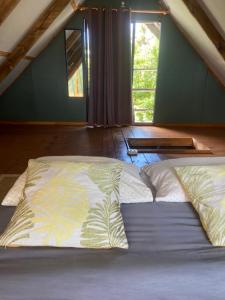 a large bed in a room with two windows at Hare Sunset Rapa Nui in Hanga Roa
