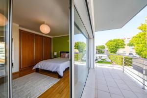 a bedroom with a bed and a balcony at Nazare House4you in Nazaré +62 photos
