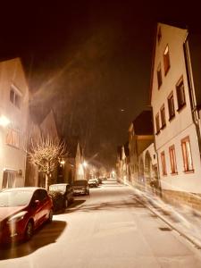 Eine Straße bei Nacht mit auf der Straße geparkten Autos in der Unterkunft Alexa in Eußenheim