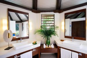 a bathroom with two sinks and two mirrors at Yasawa Island Resort & Spa in Mbukama