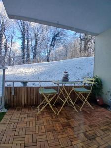 a table and chairs on a patio in the snow at Le Doubs Cosy in Besançon