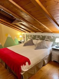 a bedroom with a large bed with a red blanket at Alojamiento Bernabales in Pámanes