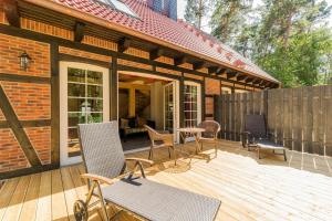 a patio with chairs and a table on a wooden deck at Welsh Dragon in Siedlung Schönwalde