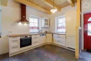 a kitchen with white cabinets and a stove at Welsh Dragon in Siedlung Schönwalde