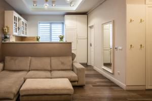 a living room with a couch and a kitchen at Apartament de lux central in Satu Mare