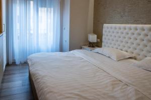a bedroom with a large white bed and a window at Apartament de lux central in Satu Mare