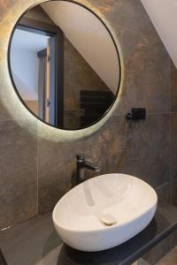 a bathroom with a white sink and a mirror at Apart M in Krynica Zdrój