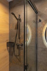 a shower in a bathroom with a glass door at Apart M in Krynica Zdrój