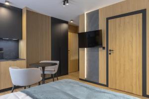 a bedroom with a bed and a table and a television at Apart M in Krynica Zdrój +64 photos