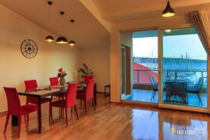 a dining room with a table and chairs and a balcony at Apartments KIDS in Kaštela