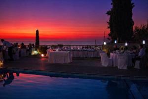 a group of people sitting around tables with a sunset at Villa Vera in Agios Nikitas +73 photos