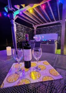 a bottle of wine and two wine glasses on a table at Red Robin Cottage in Castlewellan +22 photos