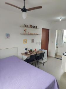ein Schlafzimmer mit einem Bett und einem Tisch mit Stühlen in der Unterkunft Flat da Lua in Viçosa