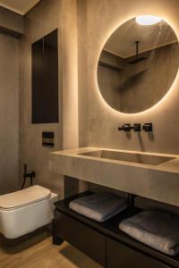 a bathroom with a sink and a toilet and a mirror at Luxury Blue Apartment in Satu Mare +5 photos