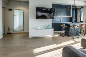 a living room with wood floors and a kitchen at Luxury Blue Apartment in Satu Mare