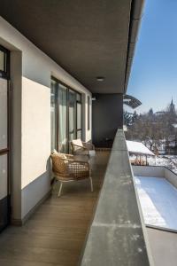a balcony with chairs and a swimming pool on a building at Luxury Blue Apartment in Satu Mare