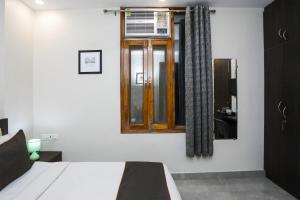a bedroom with a bed and a window at Hotel O The Signature inn in Indirapuram