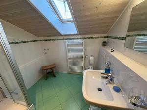 a bathroom with a sink and a skylight at Zugspitze 6 mit SAUNA in Farchant bei Garmisch-Partenkirchen in Farchant +35 photos