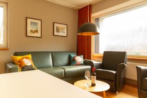 a living room with a green couch and a table at Rurtal de luxe in Simmerath +39 photos