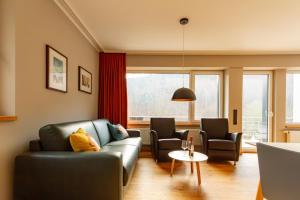 a living room with a couch and two chairs and a table at Rurtal de luxe in Simmerath