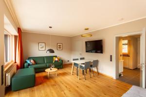 a living room with a green couch and a table at Rurtal de luxe in Simmerath