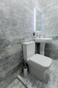 a bathroom with a white toilet and a sink at Myasnikyan Suites in Gyumri +25 photos