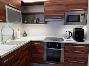 a kitchen with a sink and a stove top oven at Smarty Choice Living with FREE PARKING - Vondroušova in Prague