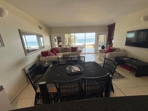 a living room with a table and chairs at GARDEN ON THE BEACH in Umdloti