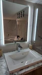 a bathroom with a sink and a large mirror at Vikendica 937 Lux & Spa, Istočno Sarajevo, Pale, Jahorina i Sarajevo na 15km in Pale