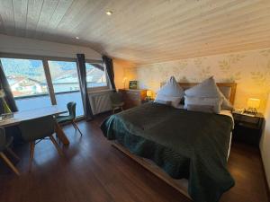 a bedroom with a bed and a desk and a desk at Zugspitze 6 mit SAUNA in Farchant bei Garmisch-Partenkirchen in Farchant