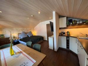 a small room with a bed and a kitchen with a table at Zugspitze 6 mit SAUNA in Farchant bei Garmisch-Partenkirchen in Farchant