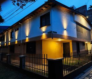 a white and yellow building with lights on it at Hotel La Casona - Cerca al Estadio Atanasio Girardot y Laureles in Medellín