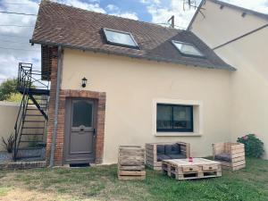 a house with a door and a bench and a table at Cocon de Fontaine in La Madeleine-de-Nonancourt