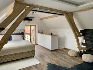 a bedroom with a large bed and wooden floors at Cocon de Fontaine in La Madeleine-de-Nonancourt