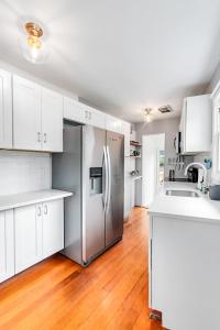 a kitchen with white cabinets and a stainless steel refrigerator at Montlake Hideaway in Spite House in Seattle