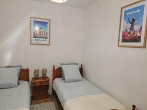 a bedroom with two beds and a picture on the wall at HoLiDaYs in Arques