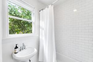 a white bathroom with a sink and a window at Montlake Hideaway in Spite House in Seattle +16 photos