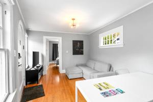 a white living room with a couch and a table at Montlake Hideaway in Spite House in Seattle