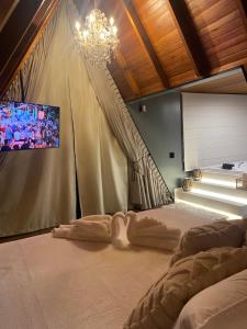 a bedroom with a bed and a tv on a wall at Cabana Espelho da Lua in Itá