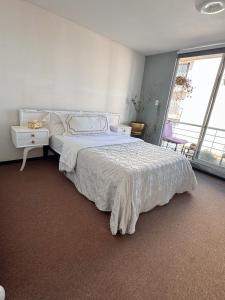 a bedroom with a white bed and a window at Cómodo departamento in Santa María Coronanco +5 photos