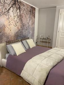 a bedroom with a large bed with a painting on the wall at Asfodelo rooms in Bra