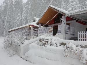 a house covered in snow in front of a house at Mistymountaincottage in Shimla +68 photos
