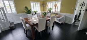 a dining room with a wooden table and chairs at Wisteria Haze in Cranfield