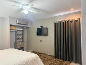 a bedroom with a ceiling fan and a shower curtain at Nueva Vizcaya & Suites in Hidalgo del Parral