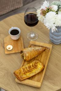 a table with a plate of food and a glass of wine at Myasnikyan Suites in Gyumri