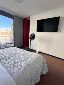 a bedroom with a bed and a flat screen tv at Cómodo departamento in Santa María Coronanco