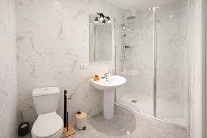 a white bathroom with a shower and a toilet and a sink at Alicante Beach Hostel in Alicante