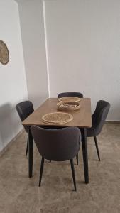 a wooden table with four chairs around it at Apartamento Bellarhouse II in Ciudad Real
